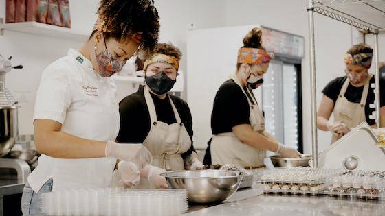 A chef working with her team in a busy shop